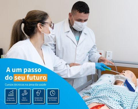 Dois profissionais de saúde usando máscaras e jalecos brancos participam de um treinamento prático em um manequim de simulação médica. Eles estão realizando procedimentos em um ambiente de ensino, com foco em aprimorar habilidades clínicas.